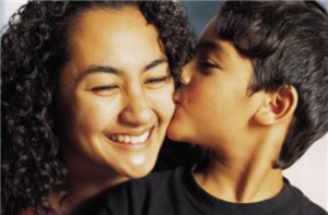 young boy kissing woman